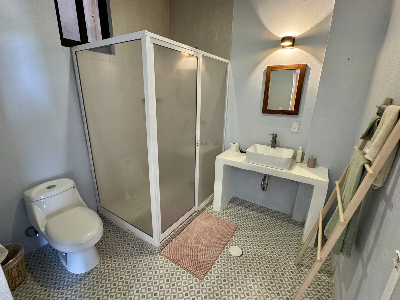 Baño privado con regadera, lavabo sobre cubierta y piso de mosaico