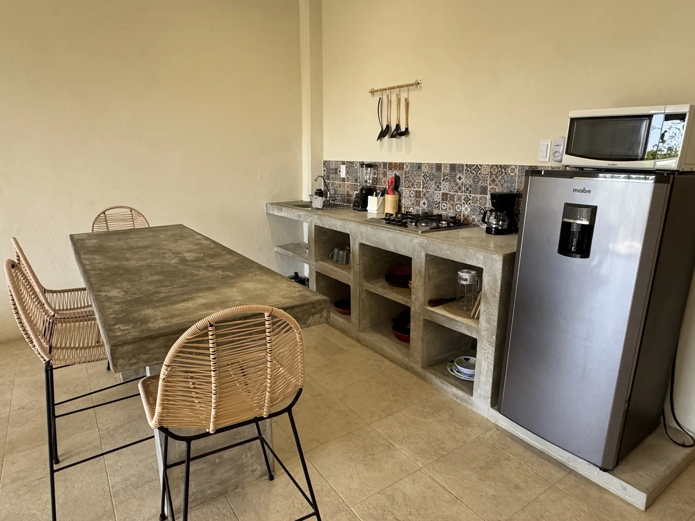 Cocina equipada con barra comedor y bancos tejidos