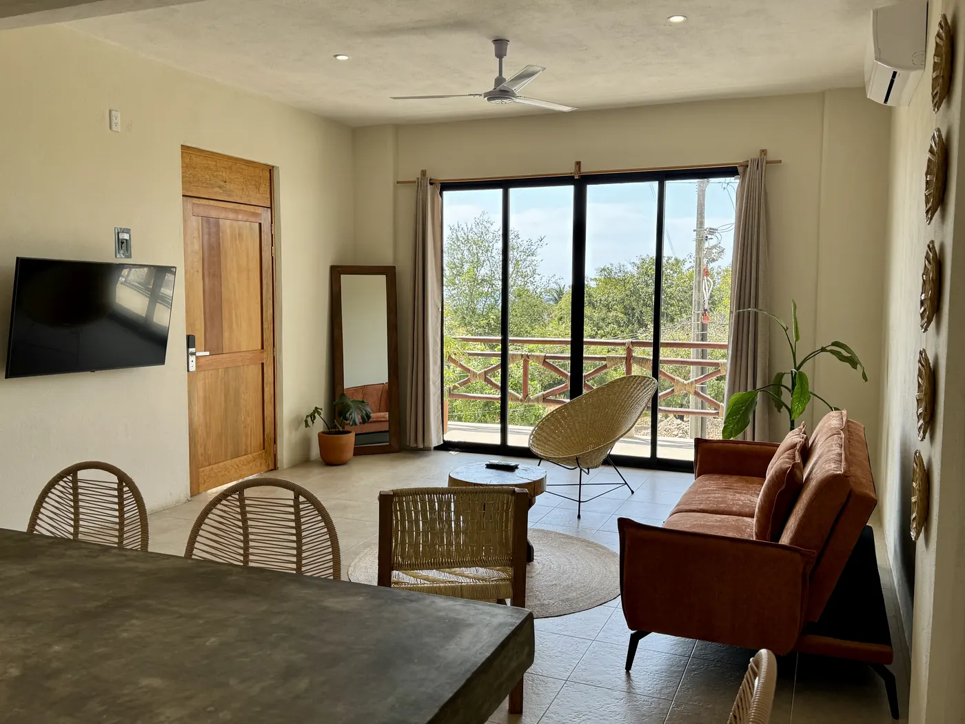 Estancia con comedor, TV, sala y ventanal al balcón